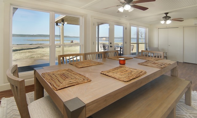 dining area with ceiling fan, hardwood / wood-style floors, and a water view