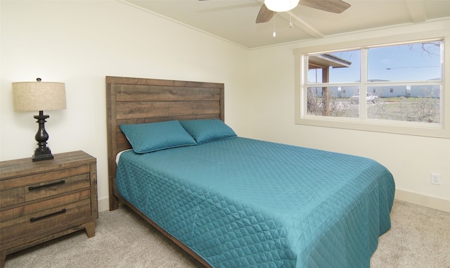 carpeted bedroom featuring ceiling fan and crown molding