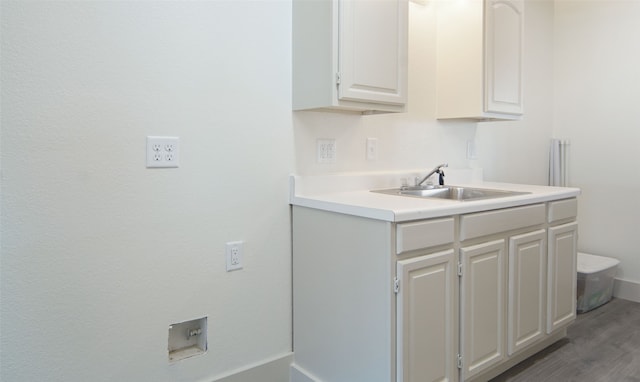 interior space featuring white cabinets, wood-type flooring, and sink