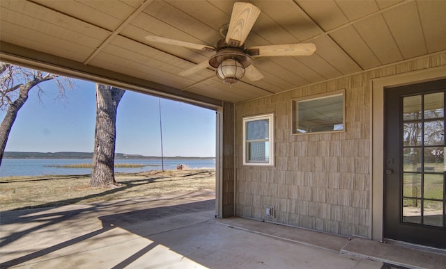 view of terrace with ceiling fan and a water view