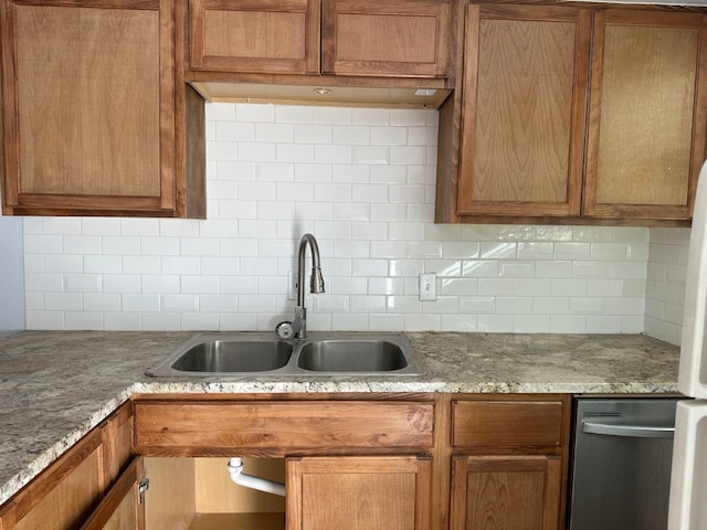 kitchen featuring light stone countertops, sink, backsplash, and dishwasher