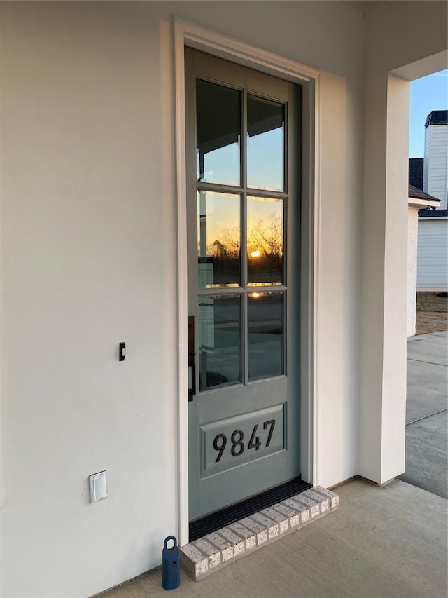 exterior entry at dusk featuring stucco siding