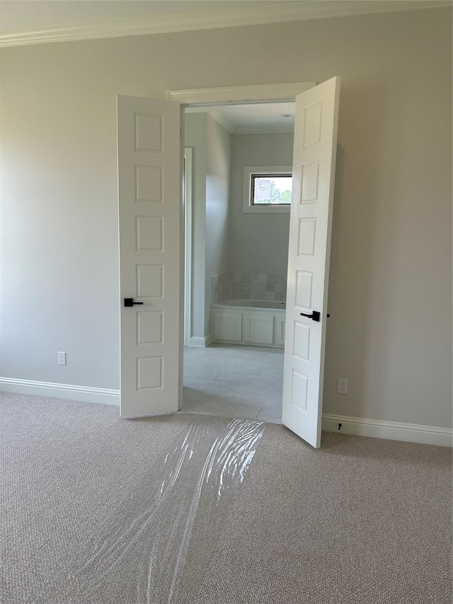 unfurnished room with light colored carpet, baseboards, and ornamental molding