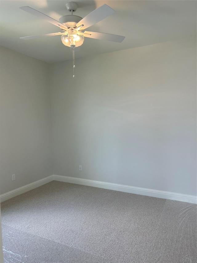 unfurnished room featuring a ceiling fan, carpet, and baseboards