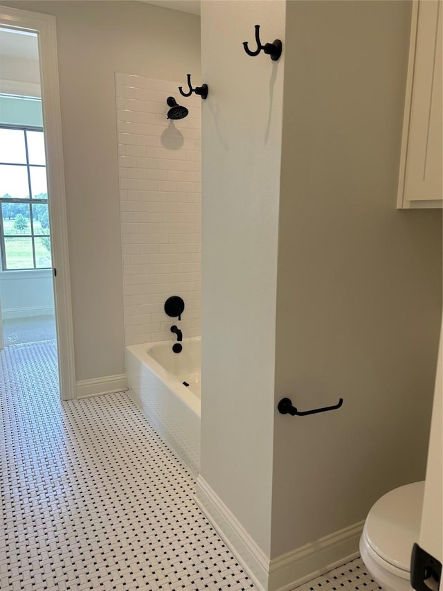 bathroom featuring baseboards, toilet, and shower / bathtub combination