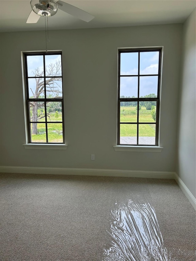 unfurnished room featuring baseboards, carpet, and ceiling fan