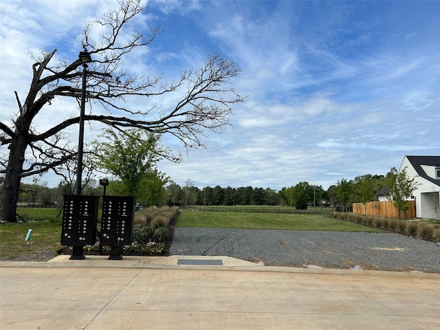 exterior space with a lawn, mail area, and fence