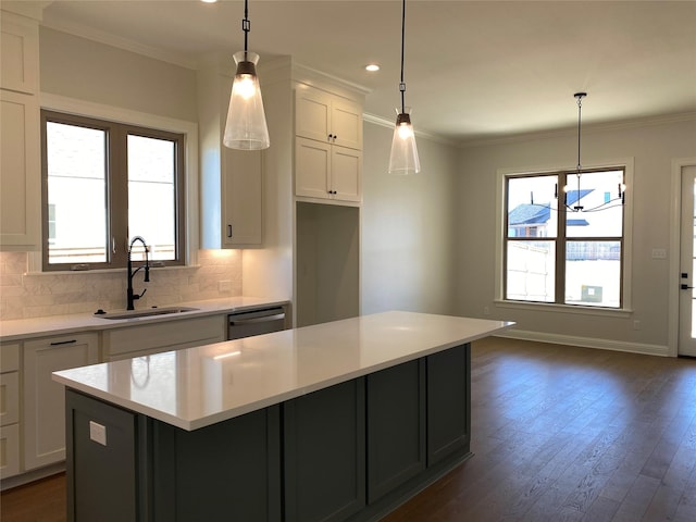 kitchen featuring white cabinetry, a center island, sink, and hanging light fixtures