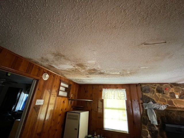 interior details with wood walls and a textured ceiling