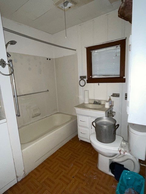 full bathroom featuring toilet, vanity, washtub / shower combination, and parquet flooring