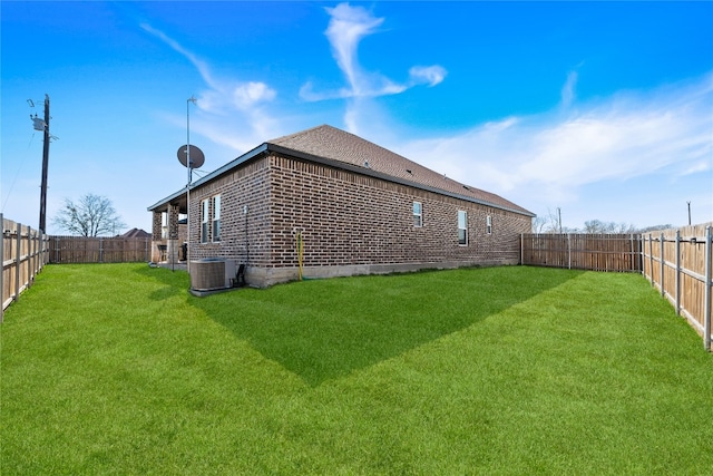 rear view of house featuring central AC unit and a lawn