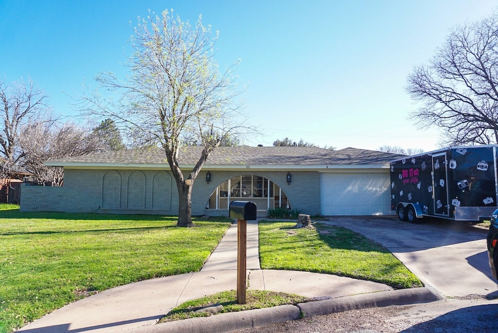 ranch-style home featuring a front lawn and a garage