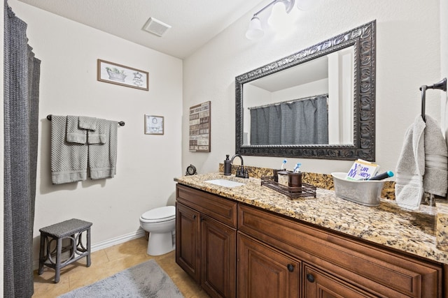 bathroom featuring tile flooring, a textured ceiling, large vanity, and toilet