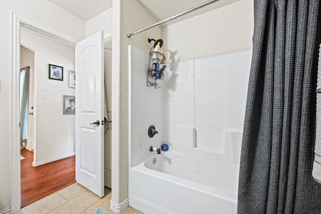 bathroom featuring shower / bath combination with curtain, tile floors, and a textured ceiling