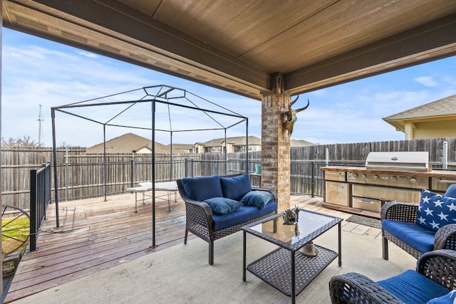 wooden terrace with an outdoor hangout area and exterior kitchen