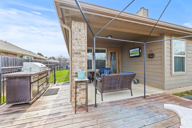 wooden deck with an outdoor hangout area, an outdoor kitchen, and grilling area