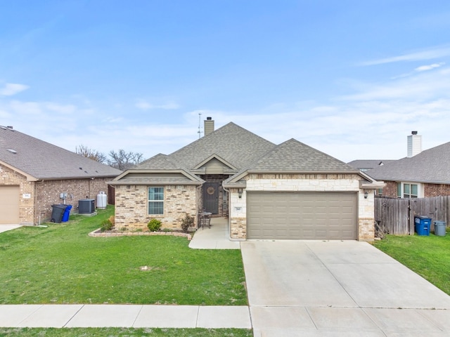 view of front of house with central AC, a front yard, and a garage