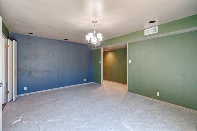 tiled empty room with an inviting chandelier