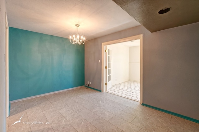 unfurnished room with a notable chandelier and light tile floors