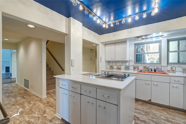 kitchen featuring sink, light tile floors, white cabinets, backsplash, and black electric stovetop