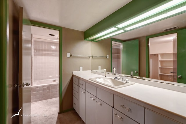 bathroom with tiled shower / bath combo and vanity