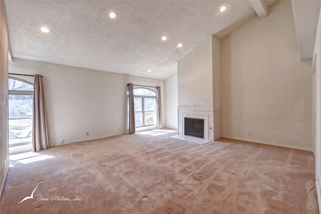 unfurnished living room with a textured ceiling, lofted ceiling with beams, and light colored carpet