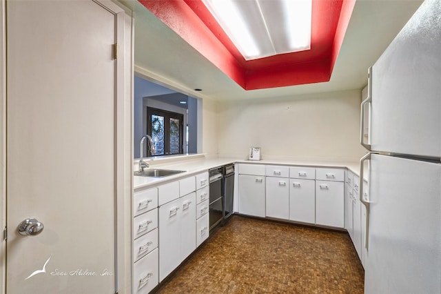 kitchen with white fridge, dishwashing machine, sink, white cabinets, and dark tile flooring