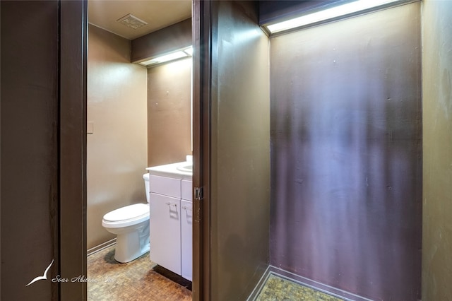 bathroom with vanity, tile floors, and toilet