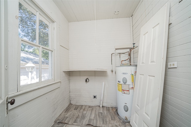 laundry room featuring hardwood / wood-style floors, electric water heater, and hookup for an electric dryer