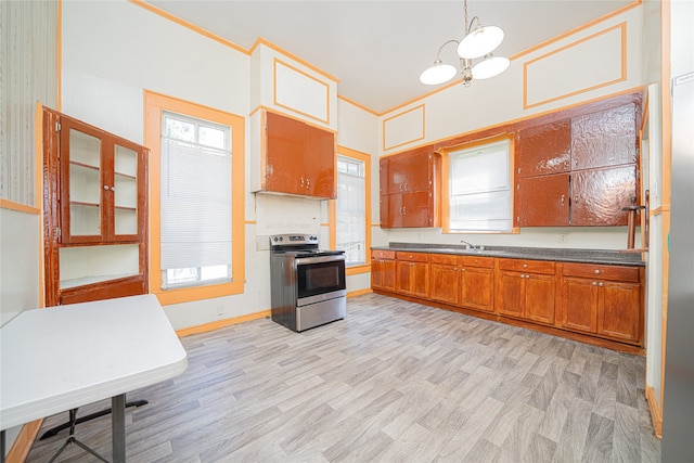 kitchen with light wood-type flooring, stainless steel range with electric cooktop, a notable chandelier, and hanging light fixtures