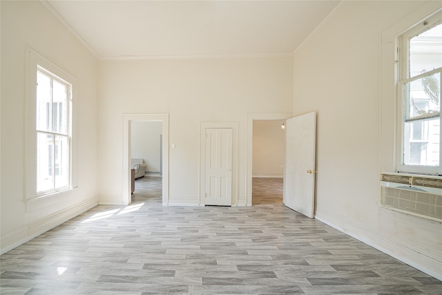 unfurnished bedroom with ornamental molding, multiple windows, and light hardwood / wood-style floors