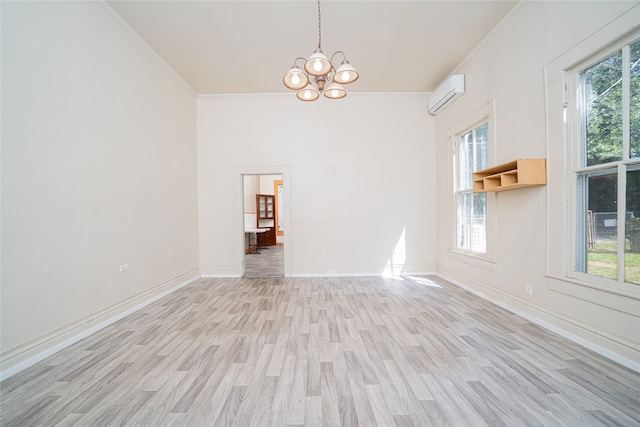 unfurnished room featuring a wall unit AC, a wealth of natural light, a chandelier, and light hardwood / wood-style flooring