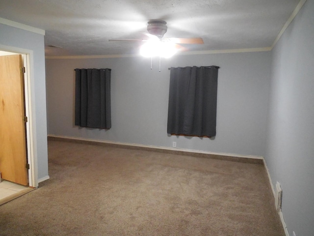 carpeted spare room featuring ceiling fan and ornamental molding