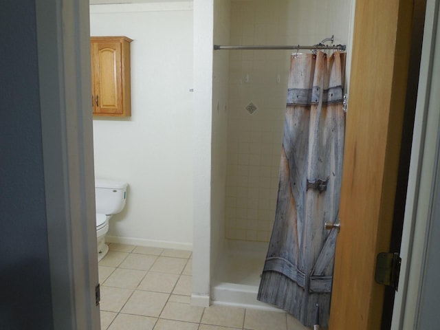 bathroom featuring tile patterned flooring, toilet, and walk in shower