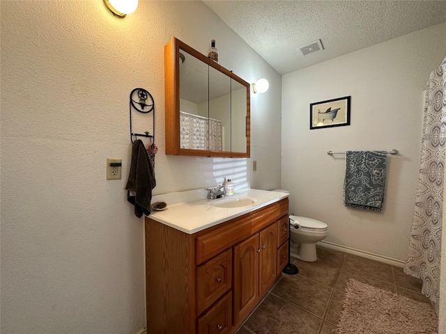 bathroom with tile floors, toilet, a textured ceiling, and vanity