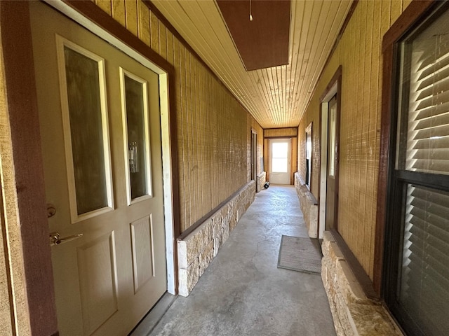 hallway with wood walls and wooden ceiling