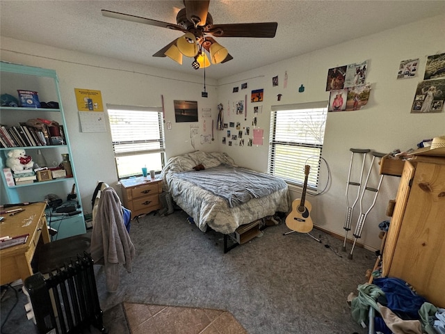 bedroom featuring dark tile floors, ceiling fan, and a textured ceiling