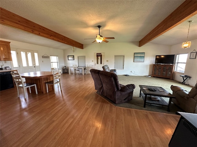 living room featuring wood-type flooring, beamed ceiling, a textured ceiling, and ceiling fan with notable chandelier