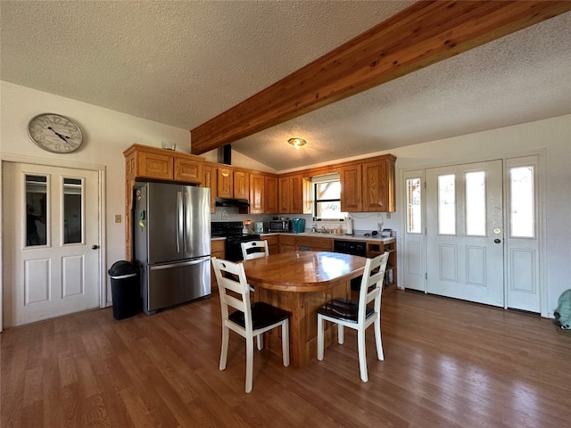 kitchen featuring dark hardwood / wood-style floors, range with electric cooktop, stainless steel refrigerator, a textured ceiling, and vaulted ceiling with beams