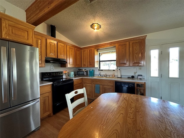 kitchen featuring hardwood / wood-style flooring, a textured ceiling, sink, and black appliances