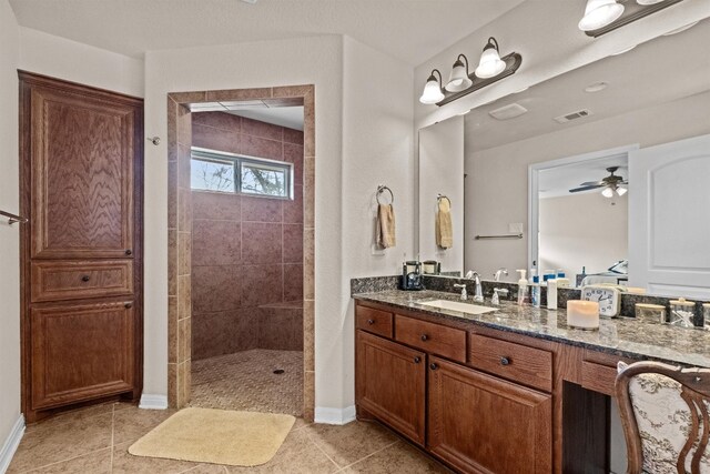 bathroom featuring vanity, tile flooring, ceiling fan, and tiled shower