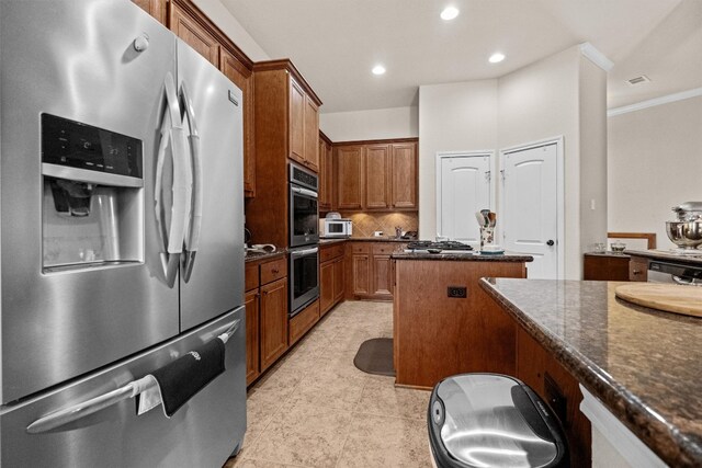 kitchen with a kitchen island, stainless steel appliances, backsplash, dark stone countertops, and light tile floors