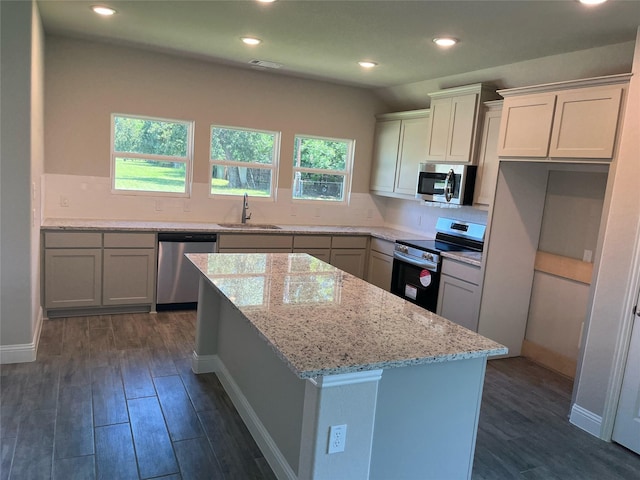 kitchen featuring sink, white cabinets, a center island, stainless steel appliances, and dark wood-type flooring