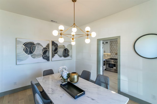 dining area featuring a chandelier and light tile flooring