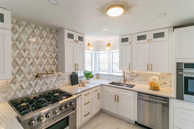 kitchen featuring backsplash, white cabinetry, stainless steel appliances, and sink