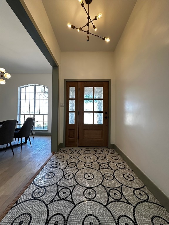 foyer entrance featuring an inviting chandelier, light hardwood / wood-style floors, and a wealth of natural light