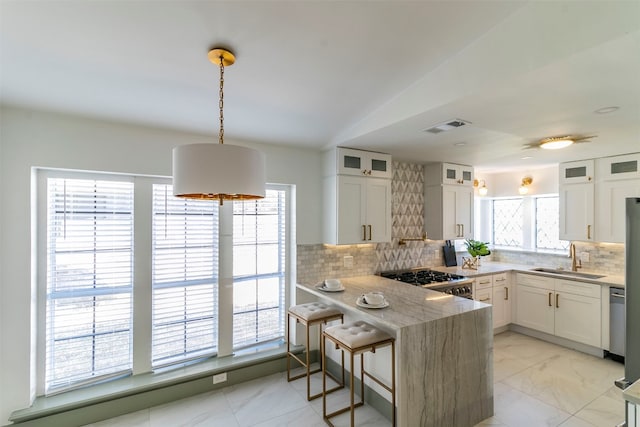 kitchen featuring white cabinetry, backsplash, and sink