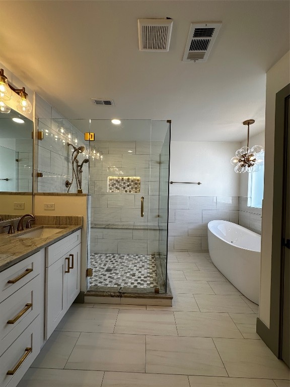 bathroom with tile walls, vanity, plus walk in shower, tile flooring, and a notable chandelier