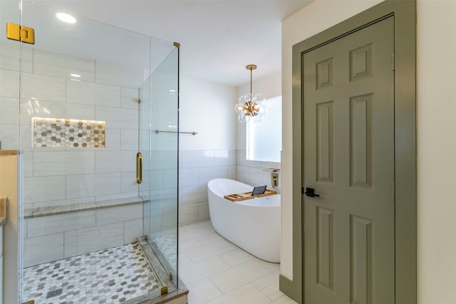 bathroom featuring tile walls, a notable chandelier, tile floors, and separate shower and tub