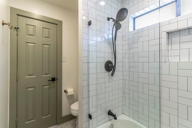 bathroom featuring toilet and tiled shower / bath